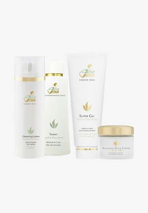 Vier Kosmetikprodukte, darunter eine Reinigungslotion, ein Toner, ein Supergel und eine Sensitiv Plus Creme, alle in weißen Behältern mit goldenen Akzenten.