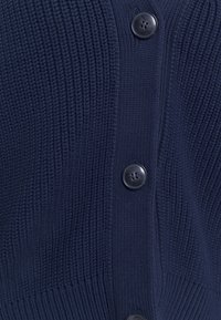 Granatowy sweter na drutach z prążkowaną fakturą i czarnymi guzikami, z zapięciem na guziki z przodu oraz miękkim, przytulnym wykończeniem.