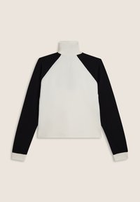 Top de manga raglán con mangas negras y cuerpo blanco, hecho de tela suave con cuello alto y puños contrastantes.