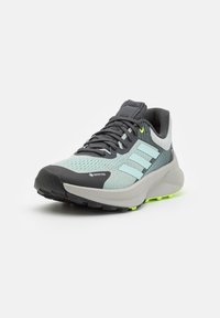 Zapatillas de running para hombre con un upper en azul claro y gris, detalles en negro, material texturizado, diseño a rayas y una suela robusta en negro.