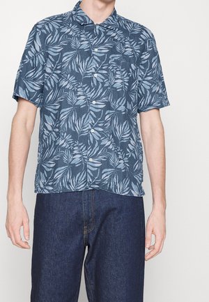 Chemise à manches courtes en tissu bleu foncé avec un motif de feuilles en bleu clair. Fermeture à boutons sur le devant et col, avec une coupe décontractée.