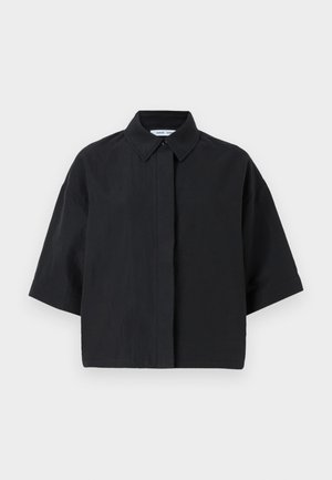 Kortermet skjorte med krage i solid svart. Laget av lett stoff med en avslappet passform. Har knappelukking foran og minimal søm.