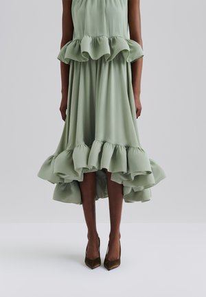 Lys grønne midi-kjole med en volangkant og bodice, lavet af glat stof, med et high-low design og parret med spidse hæle.