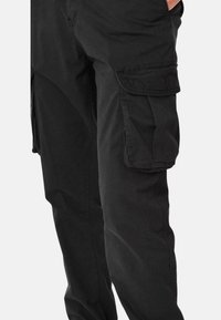 Pantaloni cargo neri realizzati in tessuto resistente, dotati di tasche laterali, una vestibilità comoda e una texture liscia.