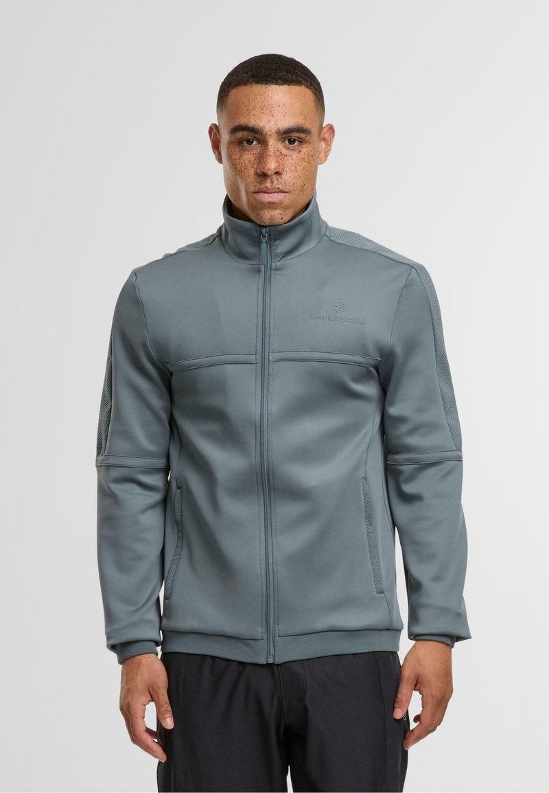 Szara bluza z zamkiem błyskawicznym, z wysokim kołnierzem, wykonana z gładkiego materiału. Posiada siateczkowe wstawki po bokach oraz na klatce piersiowej, a także subtelne logo na klatce piersiowej.