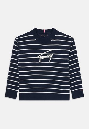 Marineblå genser med hvite horisontale striper, ribbet hals og nedkant, med en fremtredende brodert logo på fronten.