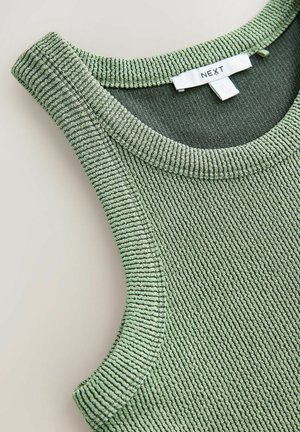 Top verde cu dungi, cu o culoare rotundă și o suprafață texturată. Eticheta spune "NEXT" pe un tag alb.