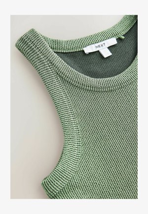 Zelený vroubkovaný top na ramínka s kulatým výstřihem a strukturálním povrchem. Na bílé cedulce je napsáno "NEXT".