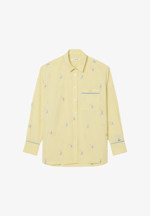 Gele overhemd met dunne blauwe verticale strepen, kleine blauwe tennisser prints, borstzakje en logo patch op de linker manchet.