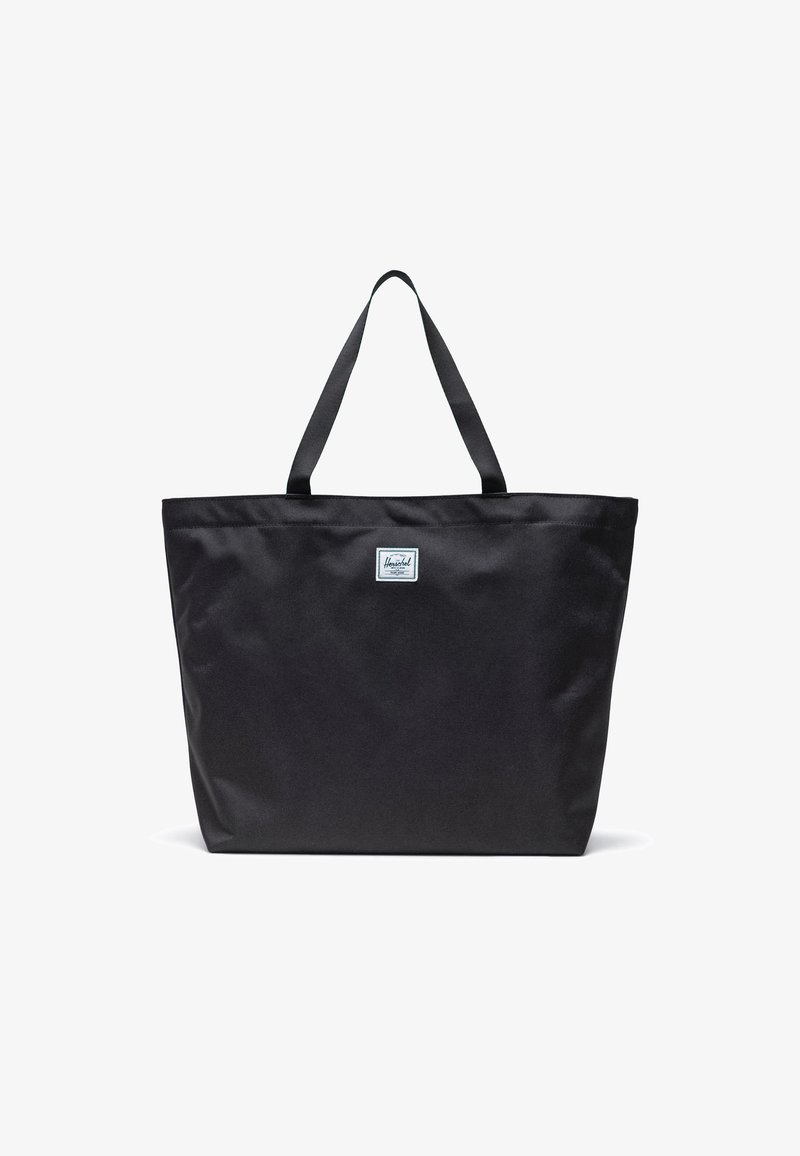 Černá taška přes rameno vyrobená z odolné tkaniny, s dvěma pevným rukojeťmi a malou wovennou značkou na přední straně. Jednoduchý obdélníkový tvar.
