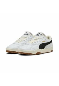 Hvide læder lavtop sneakers med en sort sideliste, tekstureret overflade og beige gummisål. Har tekstureret snørrede og branding detaljer.