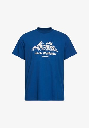 Maglietta di cotone blu a maniche corte, con grafica bianca di una montagna e testo "Jack Wolfskin EST 1981" sotto il disegno.