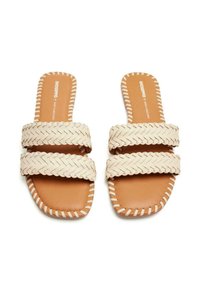 Sandales à glisser tissées beiges avec deux larges sangles, semelle de couleur marron contrastante et couture blanche autour de la semelle. Design plat, style ouvert à l'avant.