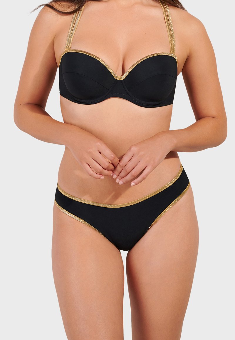 Svart bikiniset med en strukturerad bh-top med guldkanter, justerbara band och matchande bikiinibyxor med gulddetaljer längs kanterna.