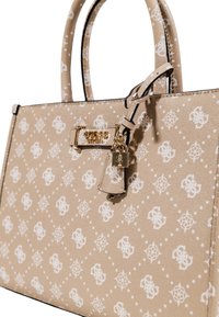 Bolso tote de cuero beige con patrón de logo blanco, herrajes dorados, asas superiores y un colgante con detalle de candado.