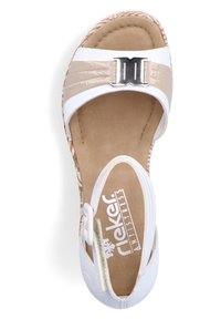 Sandale blanche avec des accents beiges, présentant un dessus en cuir verni, des détails surpiqués, une boucle en argent et une semelle intérieure rembourrée.