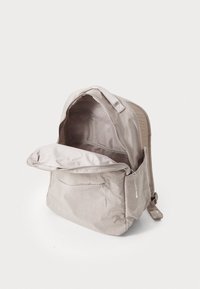 Vaaleanbeige kangasreppu, jossa on avoin vetoketju ylhäällä, paljastaen tilavan sisustan, verkkotaskun ja pehmeän vuoren. Minimalistinen muotoilu.