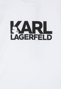 Bílá bavlněná tričko s odvážným černým nápisem "KARL LAGERFELD" a siluetou profilu. Jednoduchý design s kulatým výstřihem.