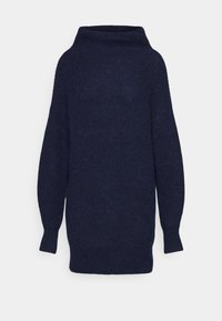 Marinblå oversized tröja med hög krage, långa ärmar och en texturerad stickad mönster. Avslappnad och löst sittande design.