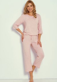 Komplet piżamowy w jasnoróżowym kolorze, składający się z luźnej góry z rękawami 3/4 oraz dopasowanych, krótkich spodni z regulowanym sznurkiem w talii. Miękki materiał o subtelnej fakturze.