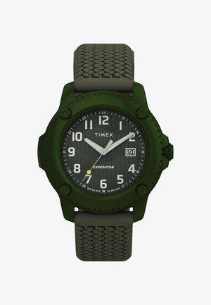 Het groene Timex Expedition horloge heeft een gestructureerde band, grote witte uurmarkeringen en een gestreepte wijzerplaat met een datumweergave en gele accenten.