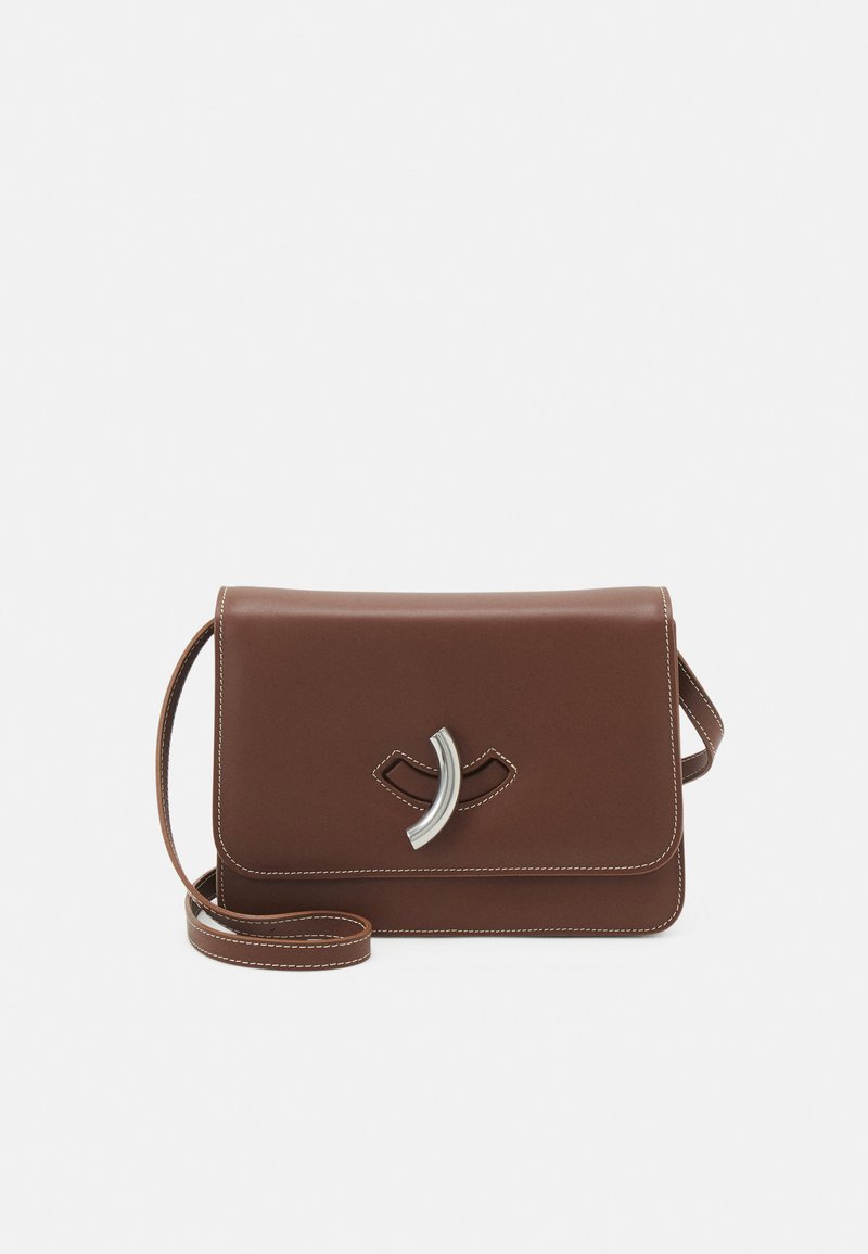 Hnedá kožená crossbody taška s prekrytím, kovovým detailom, bielym prešívaním a nastaviteľným popruhom.