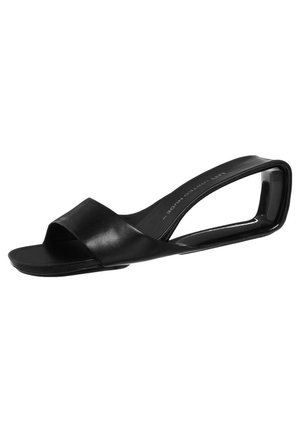 Zwarte mule sandaal met open teen, voorzien van een brede leren band en een kenmerkende gebogen, lusvormige hak.