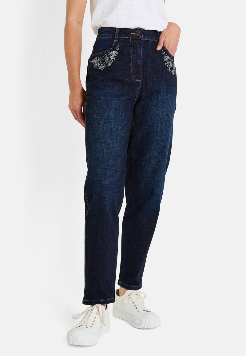 Jeans de mezclilla de un azul oscuro con bordado decorativo en blanco de flores en los bolsillos, diseño de pierna recta y un clásico cierre de botón y cremallera.