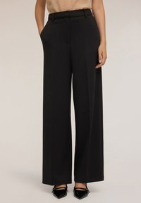 Zwarte wijde broek met een gestructureerde afwerking, voorzien van een riem, zijzakken en een stijlvolle snit die elegant valt.