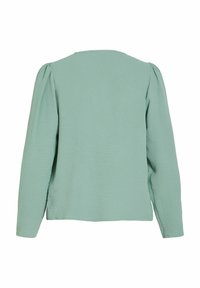 Lysegrøn bluse med lange ærmer, tekstureret finish, rund halsudskæring og bløde pufærmer. Simpelt, ubesmykket design.