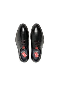 Zwarte leren schoenen met een gladde afwerking, ronde neus, rode accenten op de veters en een contrasterende zool. Binnenin bevinden zich rode merkdetails.