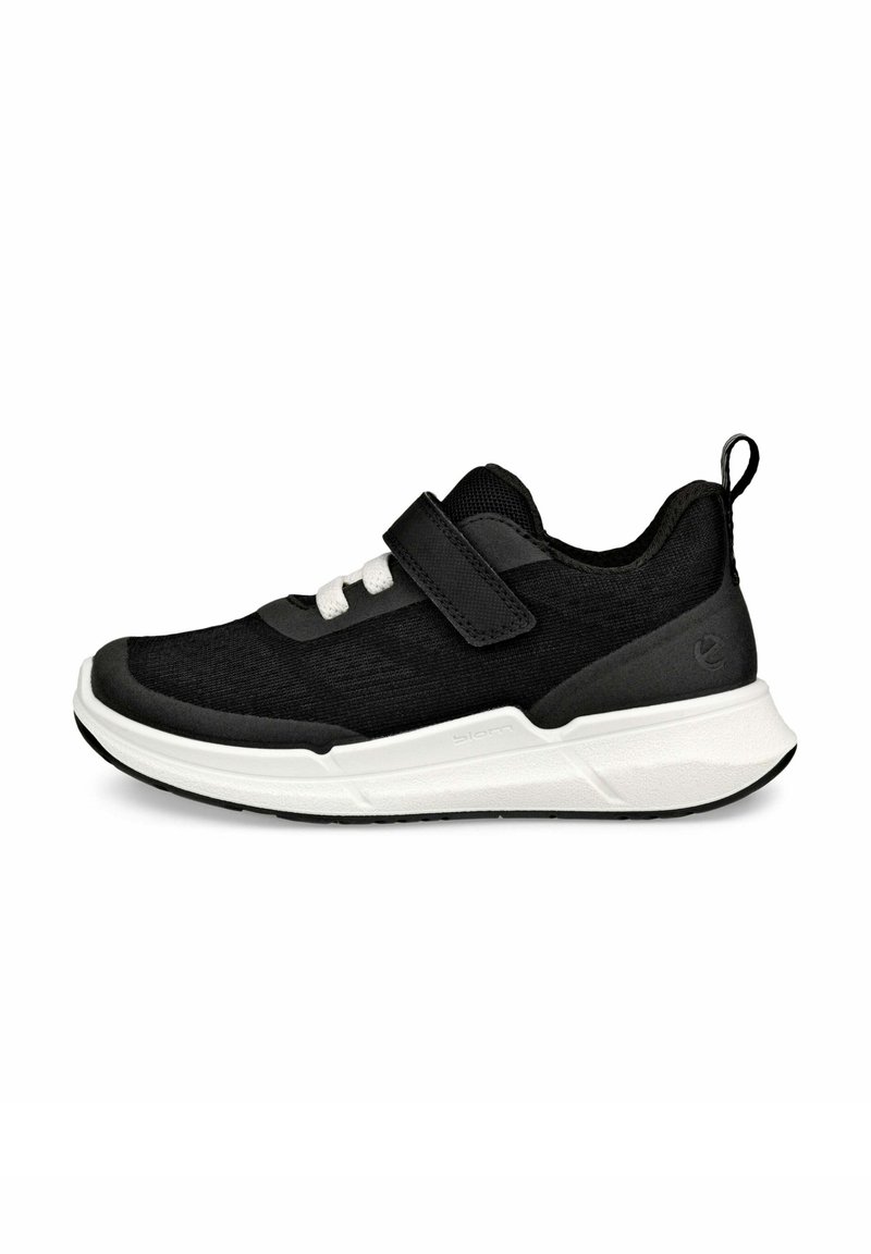 Chaussure de sport noire avec une tige en tissu texturé, semelle intermédiaire blanche et sangle velcro. Comprend une languette au talon et une semelle extérieure en caoutchouc.