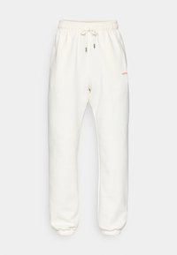 Λευκά φλις παντελόνια φόρμας με ελαστική μέση και κορδόνι. Διαθέτουν πλαϊνές τσέπες και ένα μικρό κόκκινο λογότυπο στο μπροστινό μέρος.