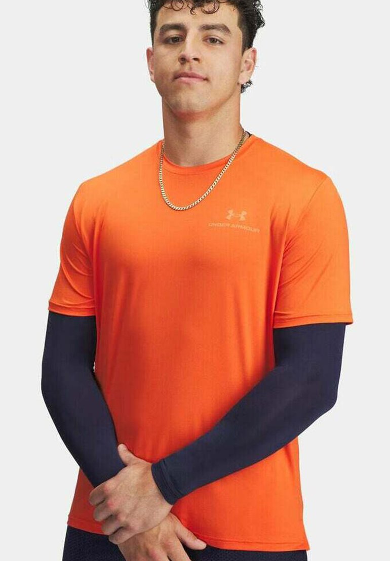 Camiseta atlética de manga corta en color naranja, fabricada con un tejido ligero, complementada con mangas largas en azul oscuro. Presenta un logo en el pecho.