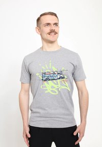 Šedé bavlněné tričko s grafickým potiskem dodávky se modro-oranžovým graffiti na pozadí jasně zeleného tintu. Krátké rukávy.