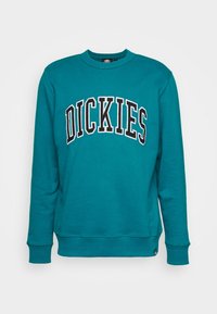 Sweatshirt teal en mélange de coton, avec un col rond, des manches longues et "DICKIES" brodé en grandes lettres noires sur le devant.