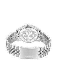 Reloj Timberland de acero inoxidable que presenta una caja redonda, pulsera de metal y logo grabado. Resistente al agua con un diseño clásico.