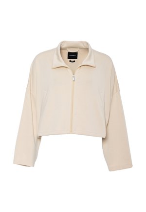 Bézs színű, rövidített, cipzáros dzseki, hosszú ujjakkal, álló gallérral és két első zsebbel.