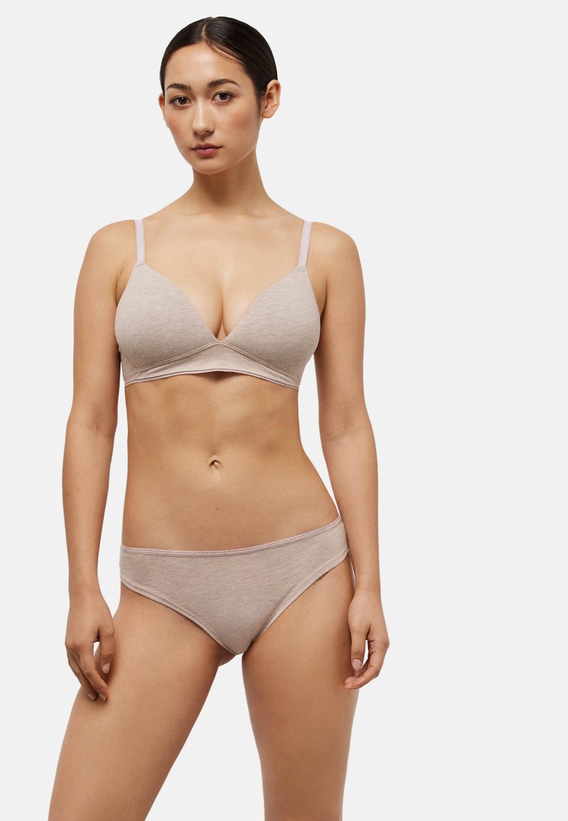 Sostén ligero de algodón beige con escote pronunciado, tirantes ajustables y bragas bikini a juego con bordes festoneados. Textura suave.