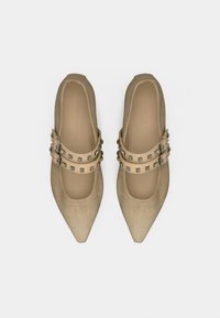 Μπεζ σουέτ μπαλαρίνες με μυτερή μύτη, διακοσμημένες με διπλές λουρίδες με αγκράφες και ασημένια καρφιά πάνω από το πάνω μέρος του ποδιού. Ομαλή εσωτερική επένδυση.