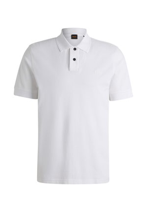 Polo shirt blanc en coton, avec un col classique, deux boutons noirs et un logo discret sur la poitrine. Manches courtes.