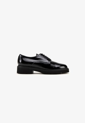 Black patent leather lace-up shoe with a rounded toe and a chunky rubber sole, featuring smooth texture and minimalistic design.