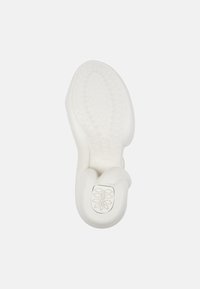 White rubber shoe sole with a curved design. Features a textured grip pattern and a smooth toe cap, highlighting its minimalist style.