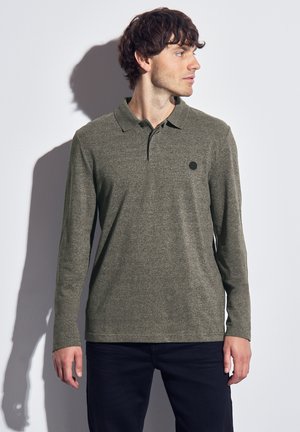 Long-sleeve polo shirt in olive green, made of textured fabric. Features a classic collar and a small black logo on the chest.