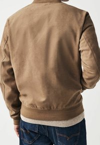 Veste bomber en daim brun avec col et ourlet en tricot côtelé, présentant une texture lisse et une silhouette ajustée.
