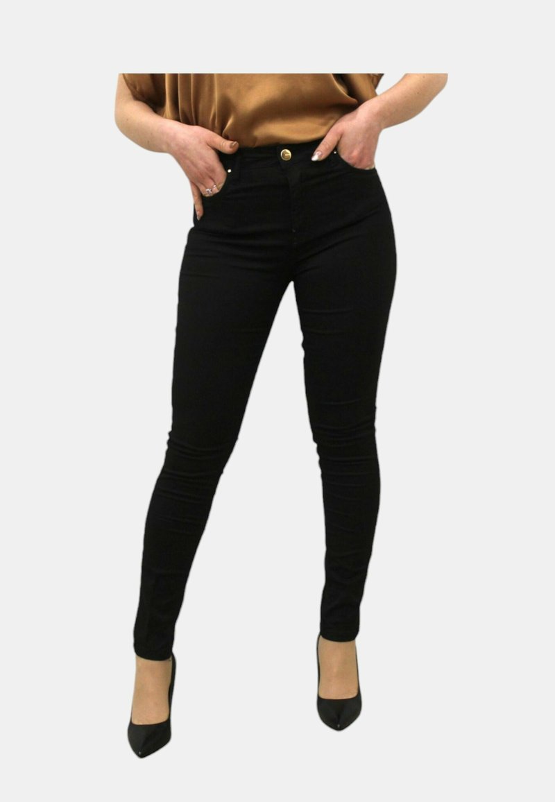 Jeans neri skinny con vita alta, dotati di chiusura con bottone dorato e tasche. Tessuto liscio, design aderente, evidenziato da tacchi alti.