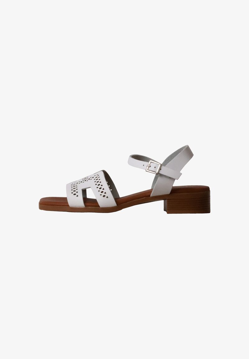 Sandale en cuir blanc avec bride avant perforée, boucle à la cheville, semelle marron rembourrée et petit talon en bois empilé.