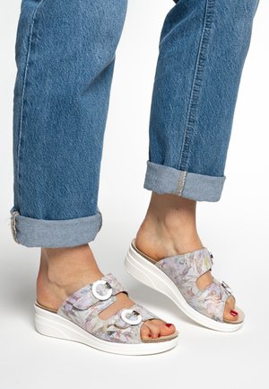 Floral-patterned wedge sandals with a white sole, featuring two decorative circular buckles; made of lightweight material and open-toed design.