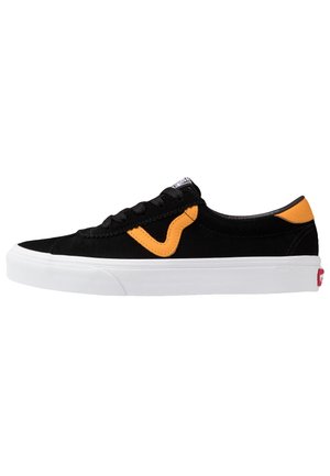 Basket basse noire avec semelle blanche, bande incurvée orange et accent au talon, vue de côté.
