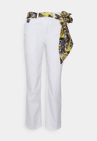 Pantalones rectos blancos con un cinturón de bufanda de patrón negro y dorado atado en el lado derecho de la cintura.
